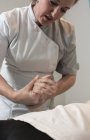 Terapeuta massaggiare mano femminile in sala massaggi — Foto stock