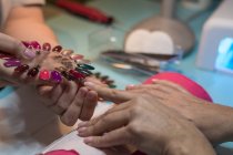 Feminino manicure mostrando unha polonês paleta para o cliente no salão de beleza — Fotografia de Stock