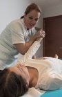 Terapeuta massaggiare mano femminile in sala massaggi — Foto stock