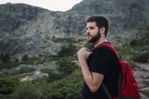 Escursioni uomo barbuto con zaino in natura di montagne — Foto stock