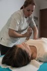 Terapeuta massageando a mão feminina na sala de massagem — Fotografia de Stock