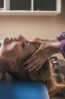 Терапевт масажує жіночу голову в масажному кабінеті — стокове фото