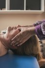 Thérapeute massant la tête féminine dans la salle de massage — Photo de stock