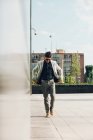 Selbstbewusster eleganter Mann mit Sonnenbrille spaziert durch die Stadt — Stockfoto