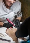 Женщина маникюрша делает педикюр клиенту в салоне красоты — стоковое фото
