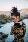 Sinnliche Frau mit fliegendem Haar steht am Seeufer — Stockfoto