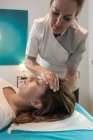 Терапевт масажує жіноче обличчя в масажному кабінеті — стокове фото