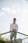 Jovem empresário alegre inclinado sobre trilhos ao ar livre — Fotografia de Stock