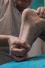Terapeuta massaggiare piede femminile in sala massaggi — Foto stock