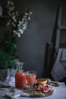 Frischer Grapefruitsaft in Glas und Flasche auf Holzbrett mit Zutat — Stockfoto