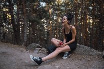Affascinante donna a riposo con zaino e tazza nella foresta — Foto stock