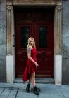 Jovem mulher atraente em pé na frente do portão velho — Fotografia de Stock