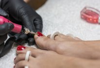 Manicura femenina haciendo pedicura al cliente en salón de belleza - foto de stock