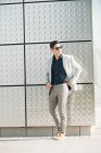 Giovane ragazzo in abito elegante in piedi vicino muro edificio — Foto stock
