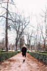 Jovem mulher em vestido vermelho andando no parque — Fotografia de Stock