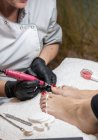 Жіночий манікюрник робить педикюр для клієнта в салоні краси — стокове фото