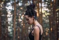 Brünette Frau steht im wilden Wald — Stockfoto