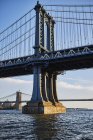 Манхэттенский мост через реку в солнечный день, Нью-Йорк, США — стоковое фото