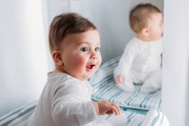 Portrait of Baby boy sitting in front of a mirror — Stock Photo