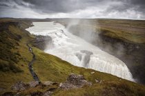 Водопад каскад и каменные скалы, Исландия — стоковое фото