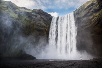 Вид снизу на мощный? невероятный каскад с каменным склоном и ручьем в Исландии, RELEASE — стоковое фото