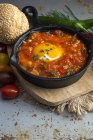 Huevo frito con tomate, pimientos rojos y pan en sartén - foto de stock