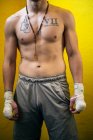 Selbstbewusster muskulöser Kämpfer, der mit bandagierten Armen dasteht und wegschaut. — Stockfoto