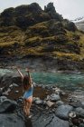 Giovane donna in piedi nel fiume di montagna — Foto stock