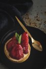 Deliciosa sobremesa cheia de creme e morangos frescos na placa preta — Fotografia de Stock