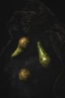 Fresh green pears on black surface — Stock Photo