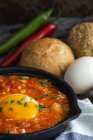 Fried egg with tomato and red peppers in frying pan — Stock Photo