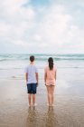Teenager friends standing on beach and looking at view — Stock Photo