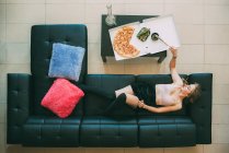 Жінка лежить на дивані з марихуанським суглобом — стокове фото