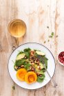 Top view of a Spinach, pomegranate and peach salad — Stock Photo