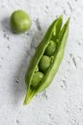 Close-up of peas on white shabby surface — Stock Photo