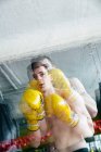 Боксер в жёлтых перчатках стоит на ринге и плохо себя чувствует во время боя. — стоковое фото