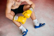 Hemdlos selbstbewusster Boxer in Handschuhen auf Hocker im Ring. — Stockfoto