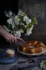 Руки повара режут буханку хлеба на тарелке. — стоковое фото