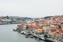 Канал и старый город с оранжевыми крышами в пасмурном виде, Порту, Португалия — стоковое фото