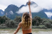 Donna con le mani in alto in montagna — Foto stock