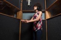 Jovem mulher cantando em estúdio — Fotografia de Stock