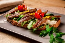 Panino con verdure e pesce su piatto grigio — Foto stock