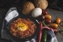 Huevo frito con tomate y pimientos rojos y verdes en sartén - foto de stock