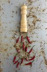Мельница специй и красный острый перец на ржавом грубом фоне — стоковое фото