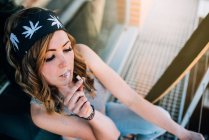 Young woman smoking a cannabis joint — Stock Photo