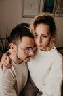 Uomo e donna premurosi seduti e abbracciati a casa insieme — Foto stock