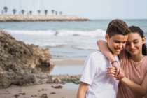 Sorridente adolescente ragazza e ragazzo in piedi sulla spiaggia — Foto stock