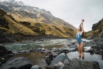Young woman standing in mountain river — Stock Photo