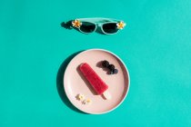 Ice cream on plate and sunglasses — Stock Photo