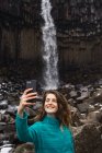 Mulher fazendo selfie perto de cachoeira — Fotografia de Stock